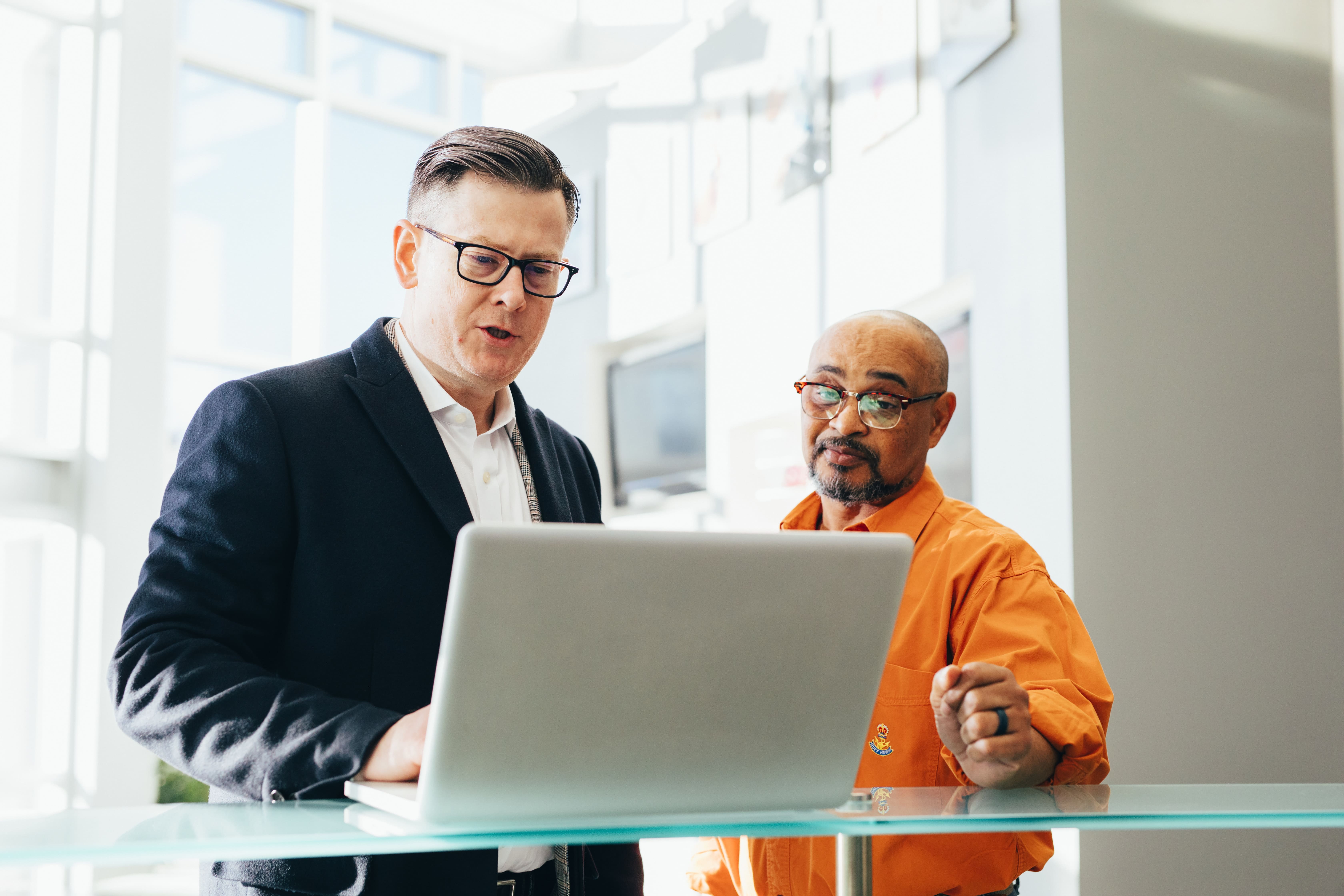 white-man-suit-black-man-computer-desk-trading-robo-advisor-roboadviser-finance